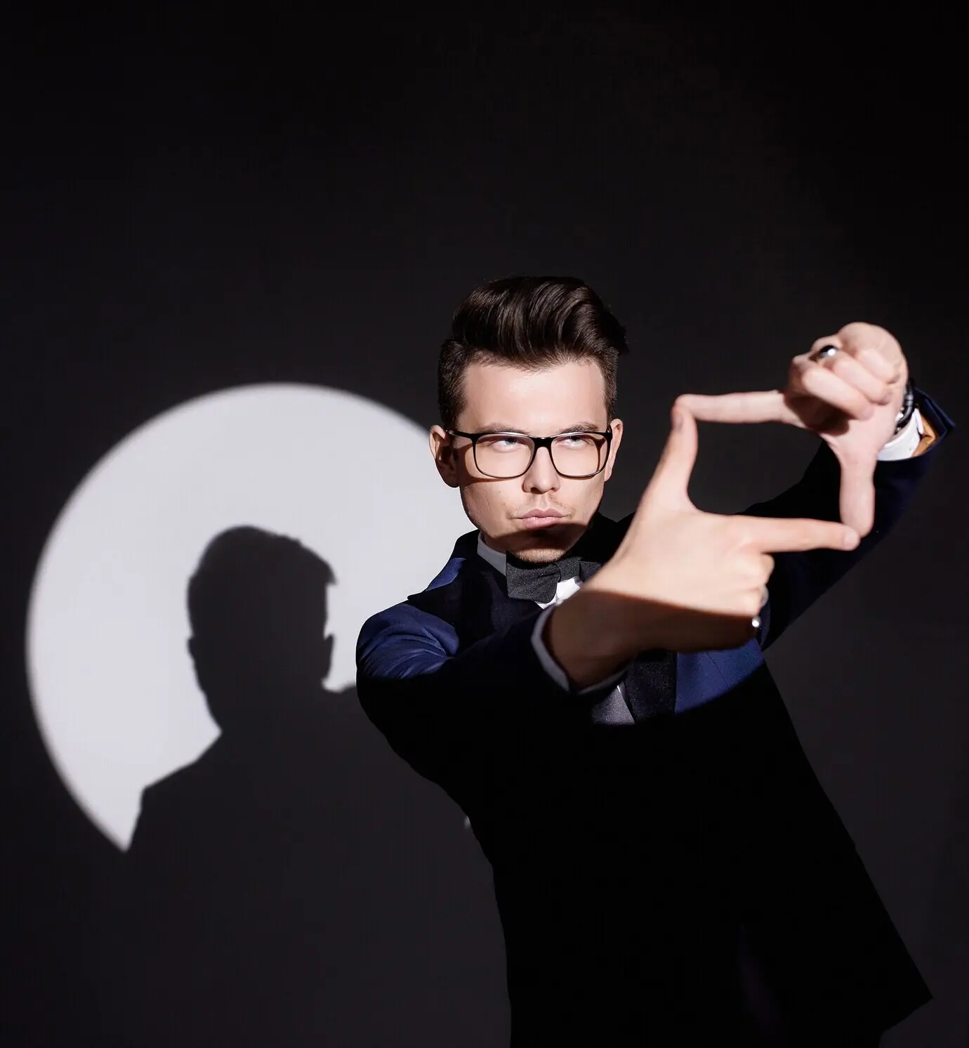 Nahaufnahme: Das Scheinwerferlicht fällt auf den jungen Mann, und er zeigt eine Geste.